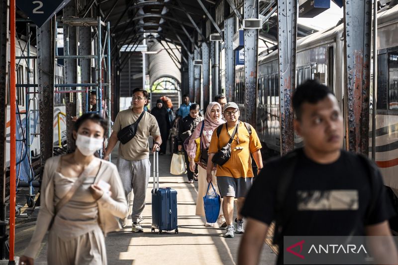 Passengers walk toward the Tawang Jaya Premium train car at Semarang Tawang Station in Semarang