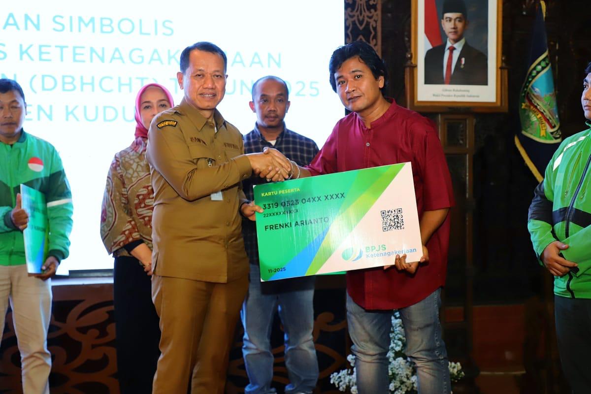 Bupati Kudus Sam’ani Intakoris menyerahkan kartu BPJS Ketenagakerjaan kepada pekerja rentan, Senin 8 Desember 2025 (foto: Pemkab Kudus)