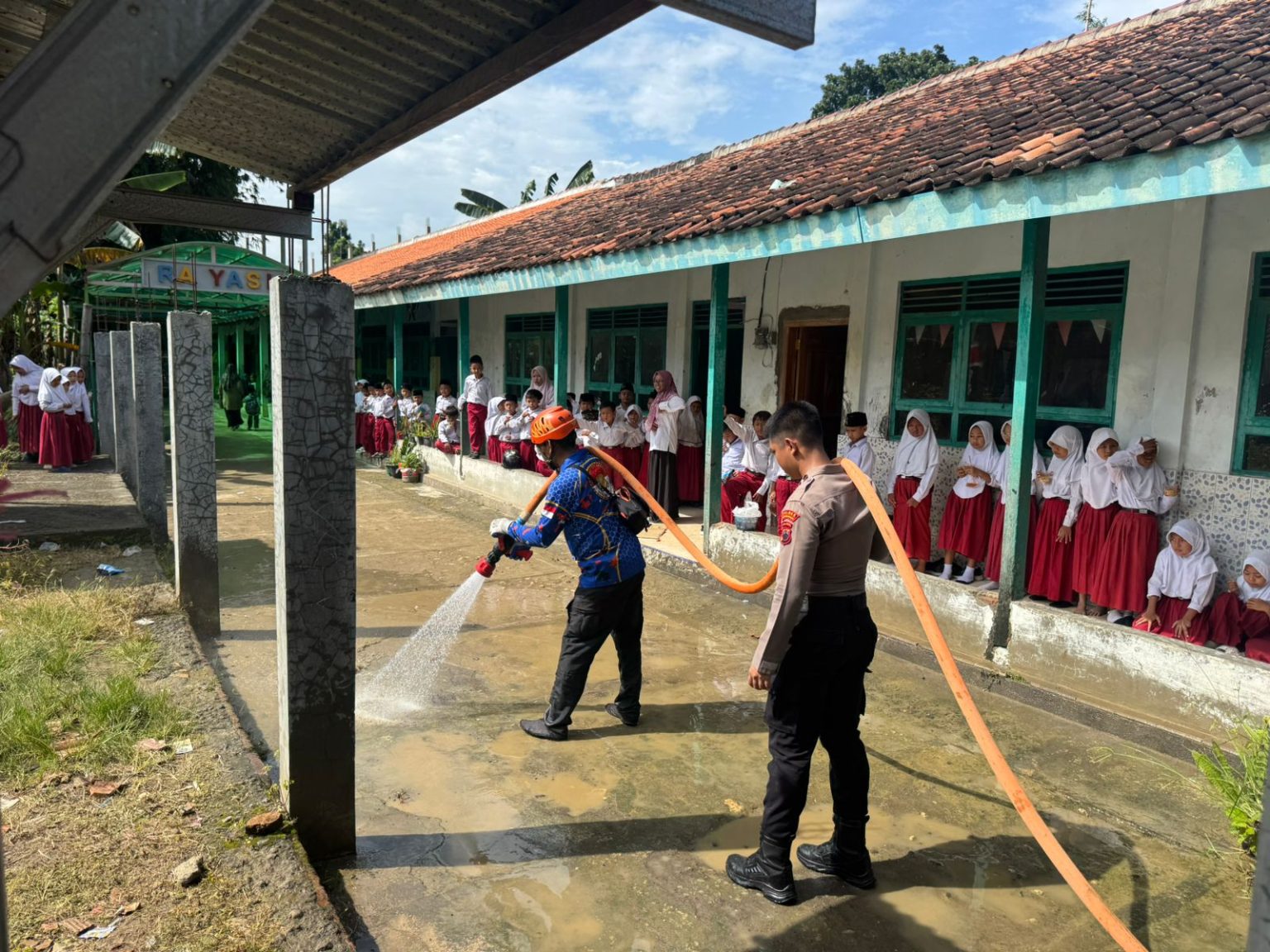 Petugas dan relawan membersihkan lumpur sisa banjir di MI Yasi Kronggen, Kecamatan Brati (foto: BPBD Grobogan)