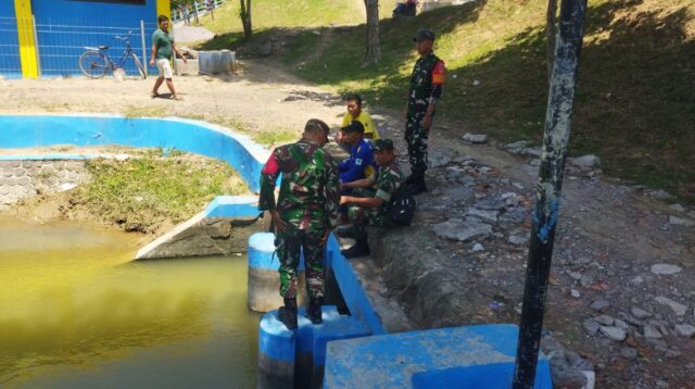 Personel Koramil Guntur memantau debit air sungai bersama warga (foto: Pemkab Demak)