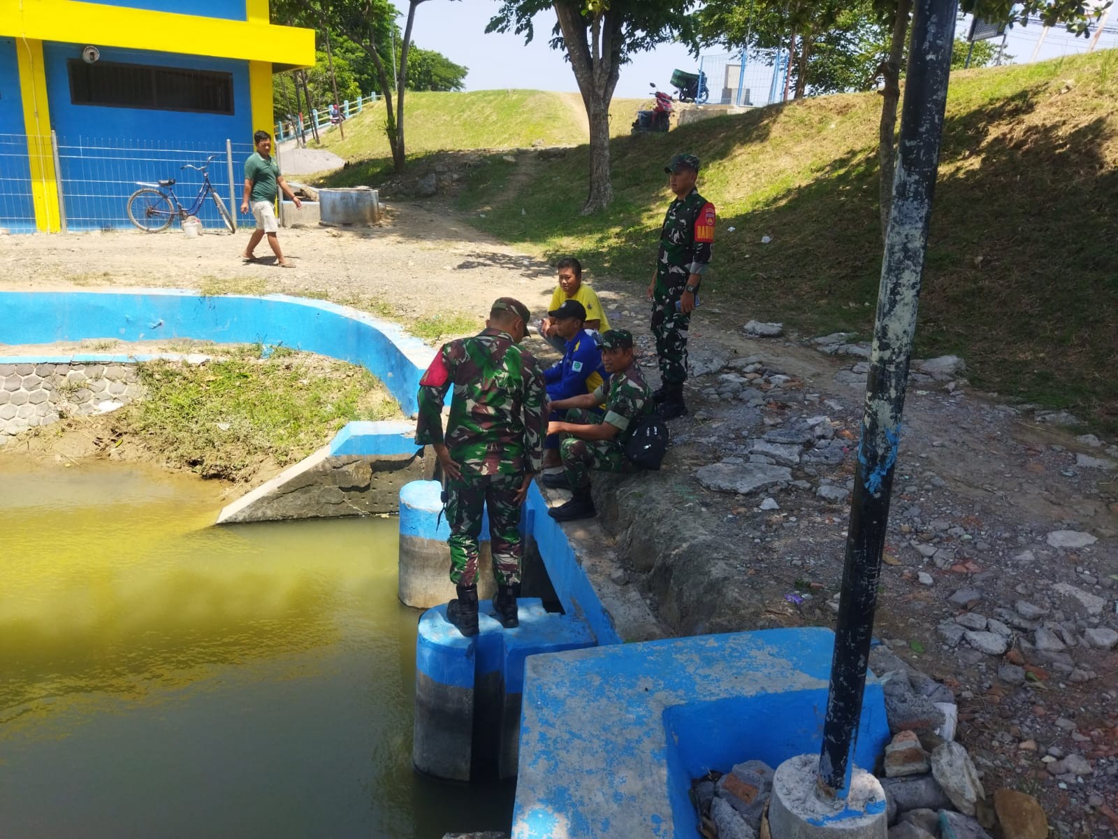 Personel Koramil Guntur memantau debit air sungai bersama warga (foto: Pemkab Demak)