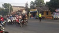 Personel Polsek Pedurungan sedang mengatur arus lalu lintas dan membantu anak sekolah menyeberang jalan saat PH pagi (foto: Polsek Pedurungan)