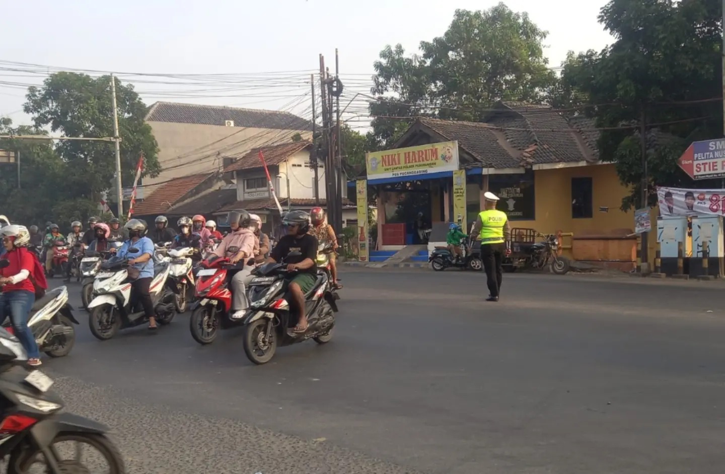 Personel Polsek Pedurungan sedang mengatur arus lalu lintas dan membantu anak sekolah menyeberang jalan saat PH pagi (foto: Polsek Pedurungan)