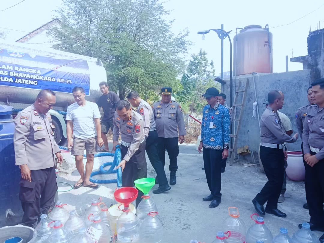 Petugas Ditlantas Polda Jateng menyalurkan air bersih dari truk tangki ke wadah penampungan milik warga di RT 02/RW 03 Kelurahan Jabungan, Banyumanik (foto: Polsek Banyumanik)
